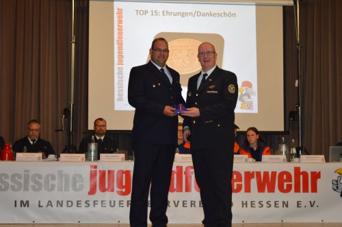 Auszeichnung mit einer Medaille auf der Bühne unter dem Banner „TOP 15: Ehrungen/Dankeschön“