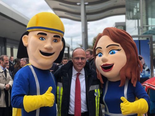 Innenminister Peter Beuth zwischen den beiden Maskottchen der Jugendfeuerwehr-Kampagne, die den Daumen hochhalten