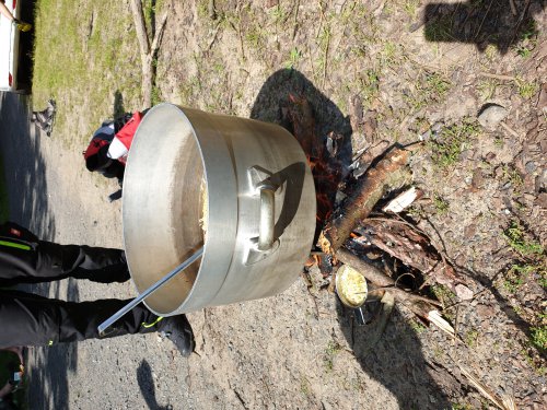 Großer Kochtopf auf einem Lagerfeuer beim Zubereiten von Essen im Freien
