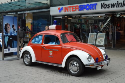 Historischer roter VW Käfer der Freiwilligen Feuerwehr als Ausstellungsstück vor einem Geschäft im Einkaufszentrum