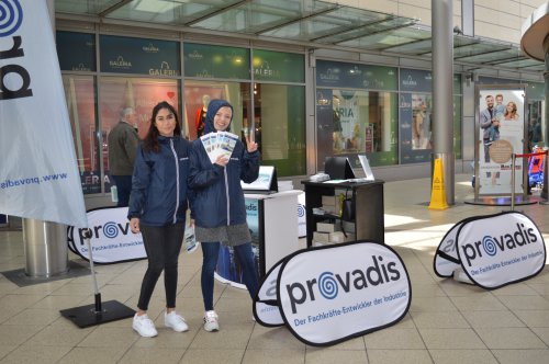 Zwei junge Frauen in blauen Jacken mit Infomaterial am Stand des Ausbildungspartners Provadis im Einkaufszentrum