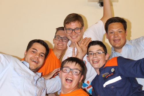 Sechs fröhliche Jugendliche der Jugendbegegnung drängen sich für ein Selfie zusammen und strecken die Hände nach oben