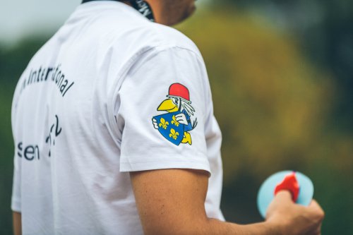 Nahaufnahme des weißen Veranstaltungs-T-Shirts mit dem Wiesbadener Wappenvogel und dem Schriftzug zur internationalen Jugendbegegnung