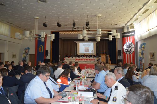 Blick in den vollbesetzten Saal des Landes-Delegiertentags mit Bannern der Hessischen Jugendfeuerwehr