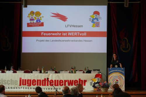 Rednerin am Pult, im Hintergrund die Projektfolie „Feuerwehr ist WERTvoll – Projekt des Landesfeuerwehrverbandes Hessen“