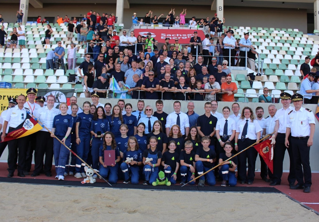Großes Gruppenfoto der hessischen Delegation mit Jugendlichen, Betreuenden und Funktionsträgern samt Hessen-Fahnen im Stadion bei den Deutschen Meisterschaften